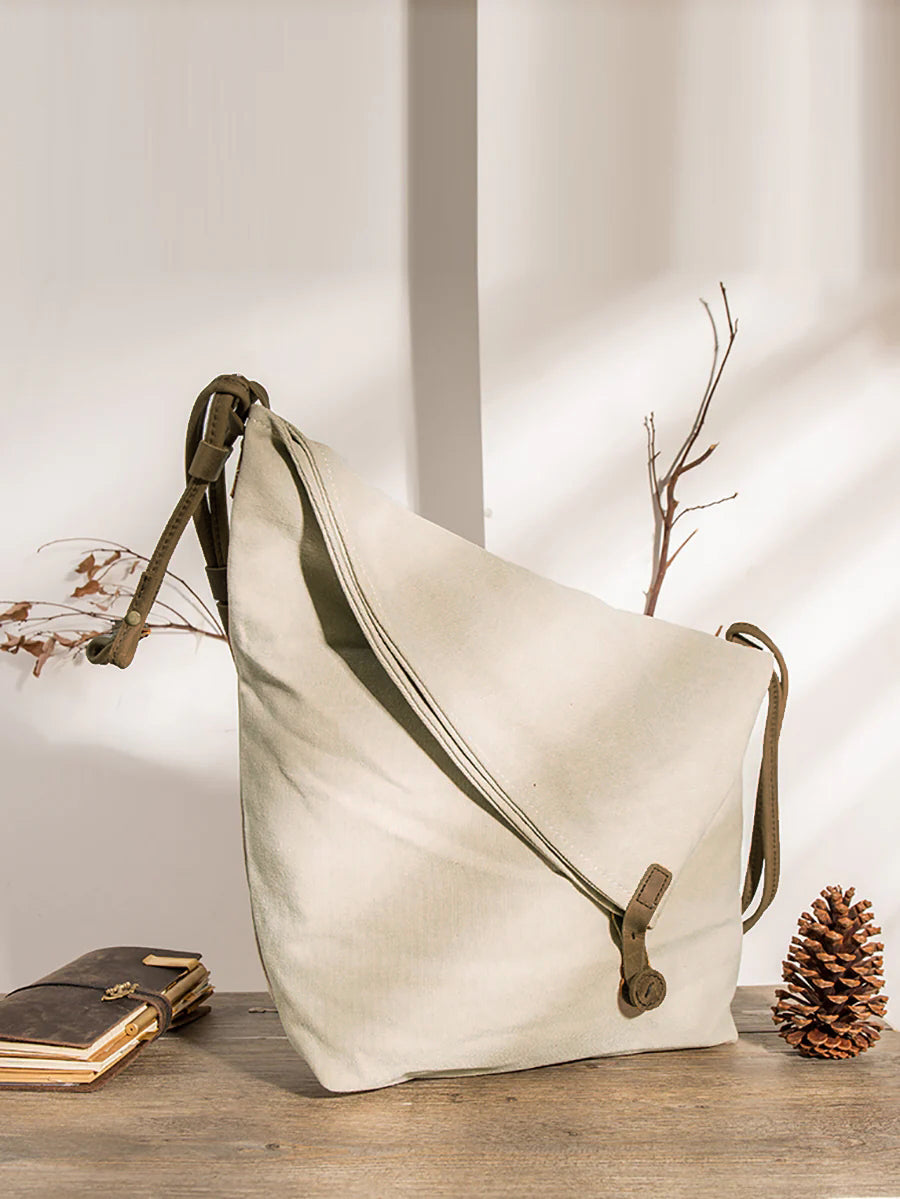 Asymmetrical folded bag with a button, adjustable and stitched