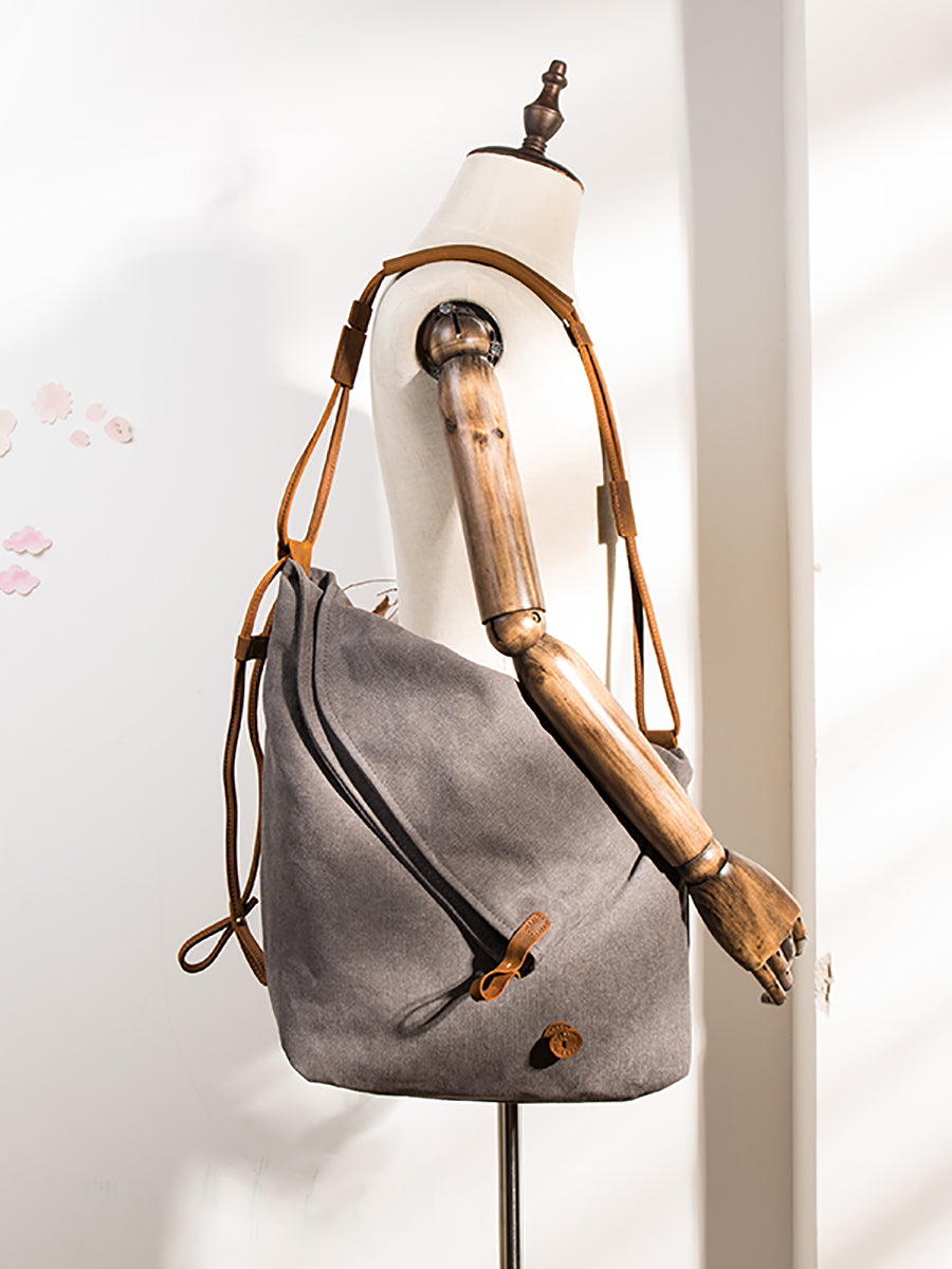 Asymmetrical folded bag with a button, adjustable and stitched