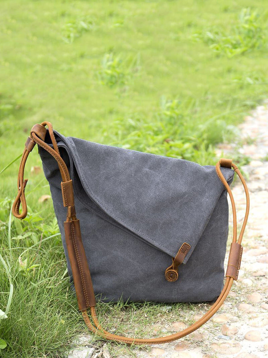 Asymmetrical folded bag with a button, adjustable and stitched