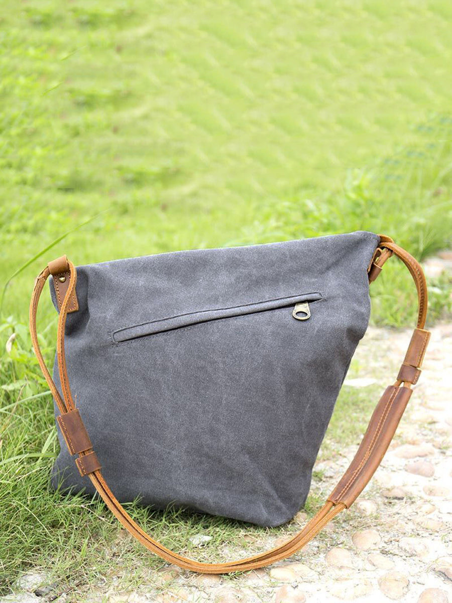 Asymmetrical folded bag with a button, adjustable and stitched